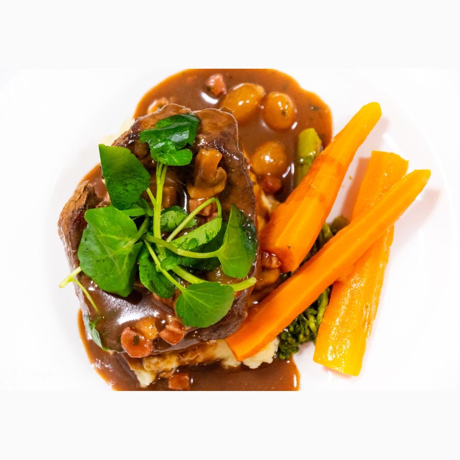 Beef with mashed potato, onions, watercress and carrots, seen from above