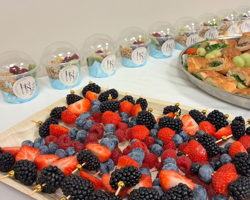 Berry and fruit skewers beside LTN Catering yoghurt pots